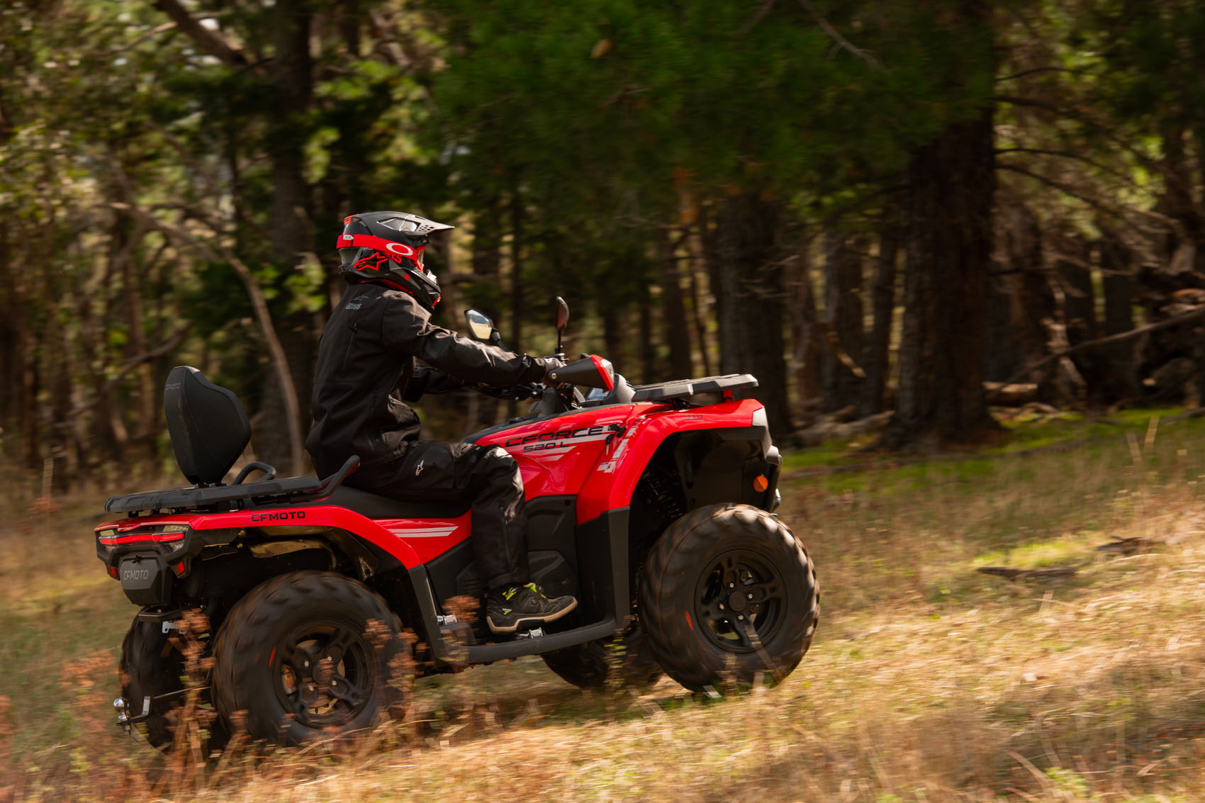 водій квадроциклу CFMOTO CFORCE 520L їде лугом у ліс