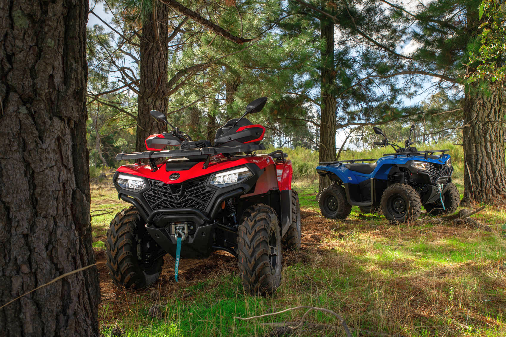 квадроцикли CFMOTO CFORCE 520 L червоний і блакитний в лісі